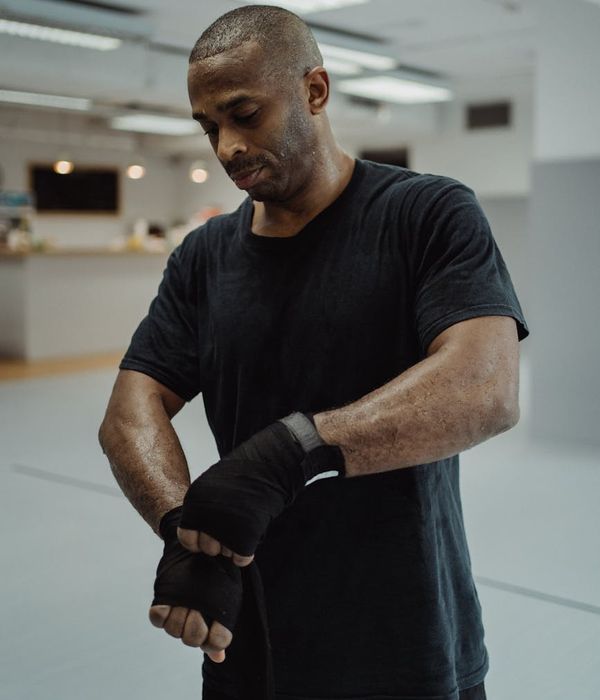 Focused man in a low-light environment preparing for a strength training exercise.